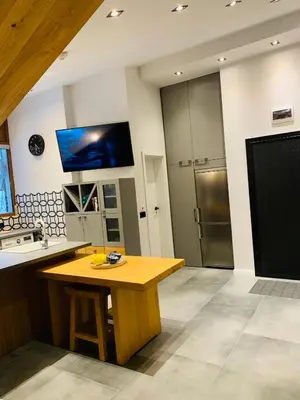 a kitchen with a wooden table and a tv on the wall at Silver Box Pamporovo in Pamporovo
