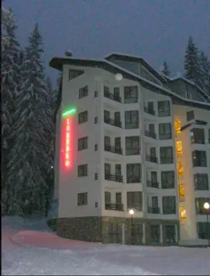 a large building in the snow at night at Silver Box Pamporovo in Pamporovo
