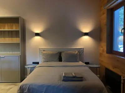 a bedroom with a large bed with two tables at Silver Box Pamporovo in Pamporovo