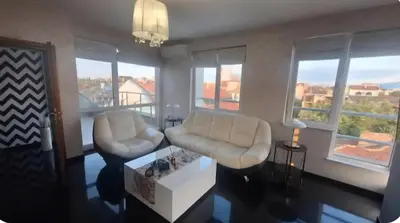 a living room with two white chairs and a table at AHINORA in Plovdiv
