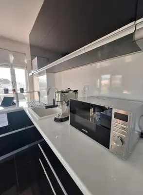 a kitchen with a white counter top with a microwave at AHINORA in Plovdiv