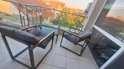 a balcony with two chairs and a fireplace at AHINORA in Plovdiv