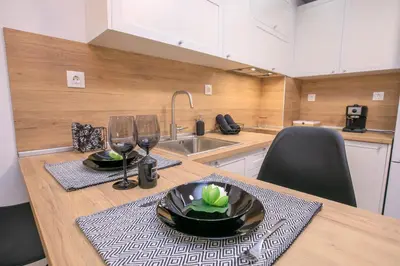 a kitchen with a table with glasses and a plate on it at Babylon Park Apartment in Sandanski