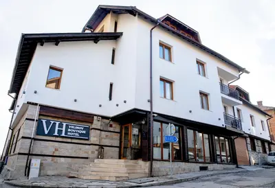 a white building with a sign in front of it at TWO BEDROOM Apartment in Bansko