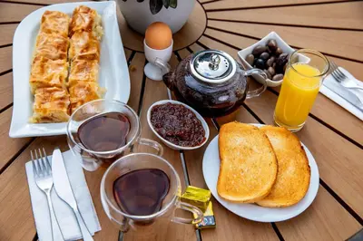 a table with a breakfast of toast and coffee and orange juice at TWO BEDROOM Apartment in Bansko