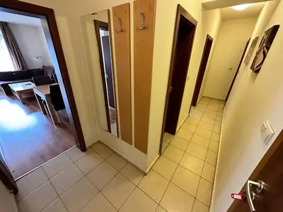 a hallway of a room with a door and a living room at Top Lodge twobedroom apartment in Bansko