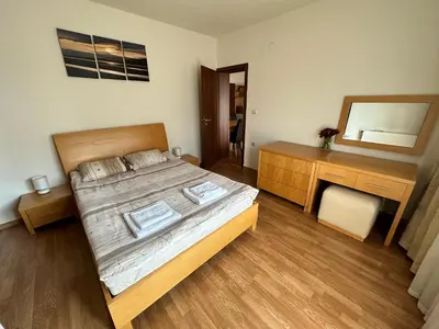 a bedroom with a bed and a dresser and a mirror at Top Lodge twobedroom apartment in Bansko