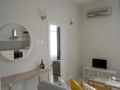 a white living room with a mirror and a tv at Caché - Bright One-Bedroom Apartment in Sofia by Flat Mаnager in Sofia