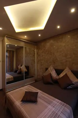 a bedroom with a large bed with a large mirror at Brown Cottage Apartment in Sofia