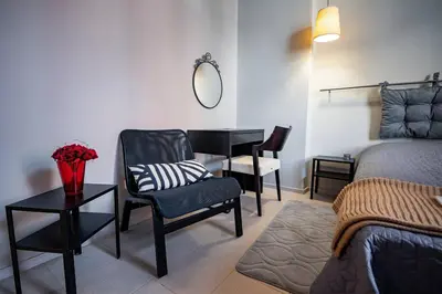 a bedroom with a bed and a chair and a table at Huge Stylish Apartment Monroe 1 / City Centre in Plovdiv