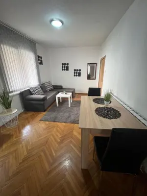 a living room with a couch and a table at Студио Рози апартамент in Sandanski