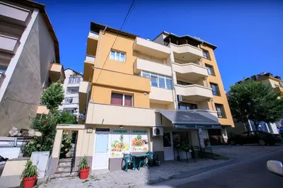 a building with a restaurant in front of it at Студио Рози апартамент in Sandanski