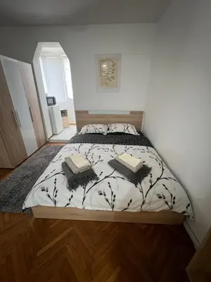 a bedroom with a bed with two books on it at Студио Рози апартамент in Sandanski