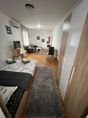a room with a bed and a living room at Студио Рози апартамент in Sandanski