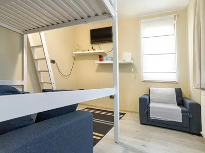 a room with a loft bed and a chair at Ancient Serdica 2BDR Family Friendly City Retreat in Sofia