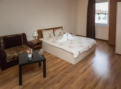 a bedroom with a bed and a chair and a table at Hotel West in Blagoevgrad