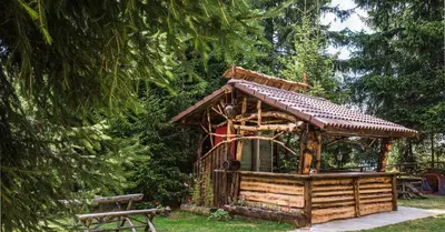 a tree house in a park with a bench at Lake View Apartment in Pamporovo