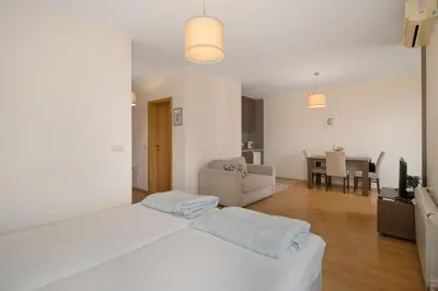 a white room with two beds and a living room at Fantastic Studio Studentski Grad in Sofia