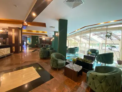 a lobby with green chairs and a waiting area at Hotel Iceberg Borovets in Borovets