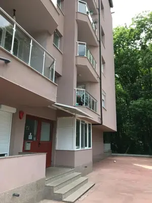 an apartment building with a red door and stairs at NORTH PARK SUITE in Sofia
