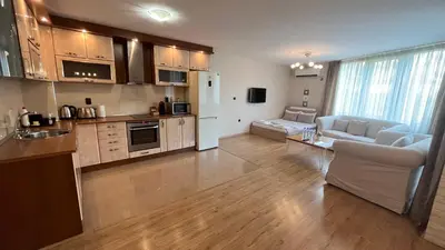 a kitchen and living room with a couch and a table at Apartment City Park Sandanski in Sandanski