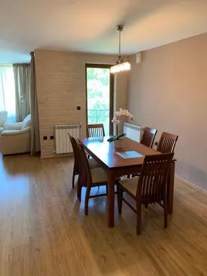 a dining room with a wooden table and chairs at Apartment City Park Sandanski in Sandanski