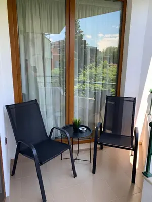 two chairs and a table in front of a window at Apartment City Park Sandanski in Sandanski