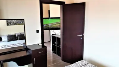 a bedroom with a desk and a tv and a mirror at Sunny Days - Park Apartment in Sandanski
