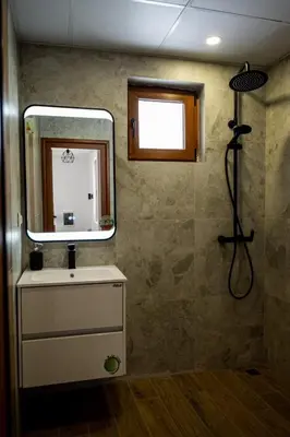 a bathroom with a sink and a mirror and a shower at Farmhopping Village in Dobărsko
