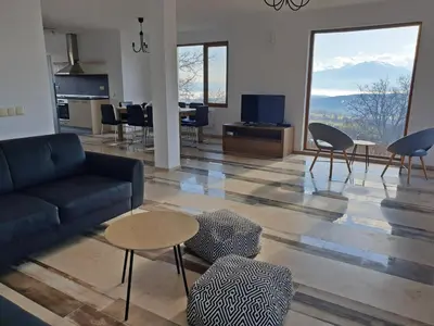 a living room with a couch and a table and chairs at Farmhopping Village in Dobărsko