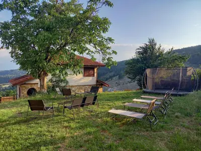 a group of chairs and a table and a house at Farmhopping Village in Dobărsko