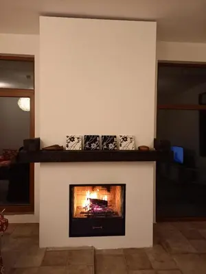a fireplace in a living room with a fire in it at Farmhopping Village in Dobărsko