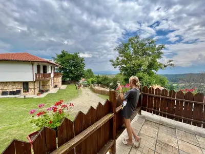 a woman standing on a fence looking at a garden at Farmhopping Village in Dobărsko