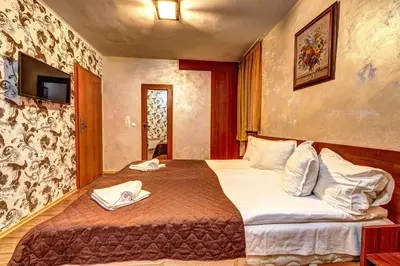 a hotel room with a bed with two towels on it at Вили Forest Nook in Pamporovo