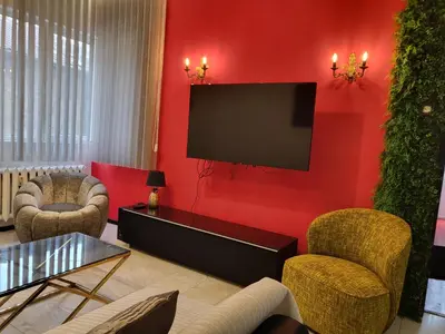 a living room with red walls and a flat screen tv at TOP CENTER spacious apartment with free parking in Sofia
