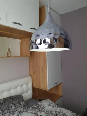 a light hanging over a bed in a room at Sunny Apartment in Blagoevgrad