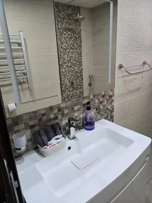 a bathroom with a white sink and a mirror at Sunny Apartment in Blagoevgrad