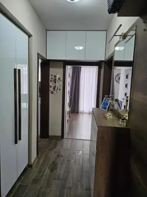 a kitchen with white cabinets and a wooden floor at Sunny Apartment in Blagoevgrad
