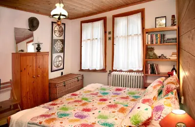a bedroom with a bed with a flowered blanket at Къща край реката - Триград in Trigrad