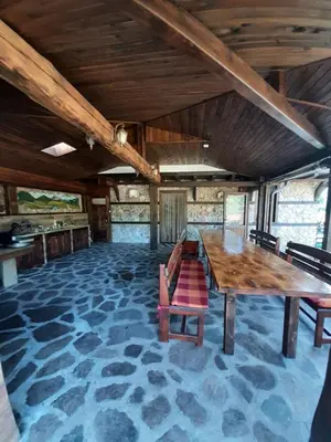 a large dining room with a wooden table and chairs at Къща за гости 