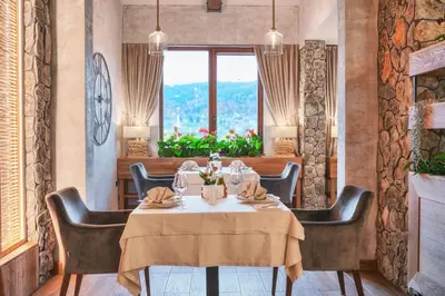 a dining room with a table and chairs and a window at SPA Complex Belchin Spring in Belchin