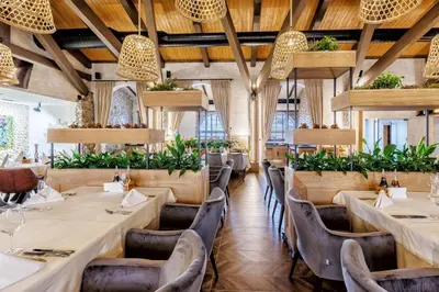 a restaurant with tables and chairs and plants at SPA Complex Belchin Spring in Belchin