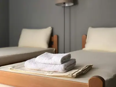 a pile of towels on a tray on a bed at Къща за гости Чечев in Sapareva Banya