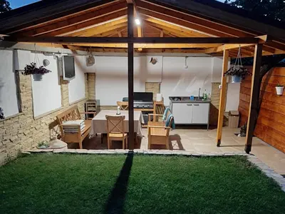 a patio with a table and chairs and a kitchen at Къща за гости Чечев in Sapareva Banya