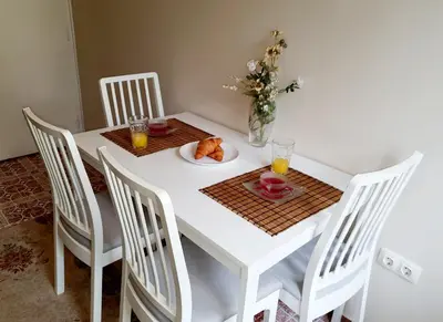 a white table with chairs and a plate of food on it at Beautiful Jewel in Top Center in Sofia