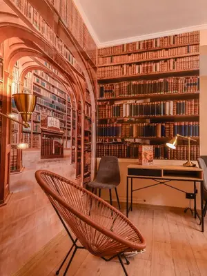 a library with a chair and a desk and bookshelves at Sofia Dream Apartment - The Library - 3-BDR, 2-BTHR by Flat Mаnager in Sofia
