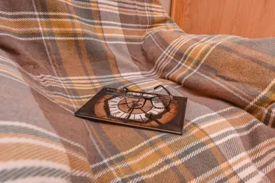 a clock sitting on top of a blanket on a bed at Sofia Dream Apartment - The Library - 3-BDR, 2-BTHR by Flat Mаnager in Sofia