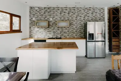 a kitchen with white cabinets and a refrigerator at Magnificent apartment in the mountains in Banite