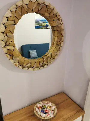 a circular mirror on a wall with a pizza on a table at Rila Apartment in Sofia