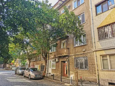 a building with cars parked on the side of a street at Rila Apartment in Sofia